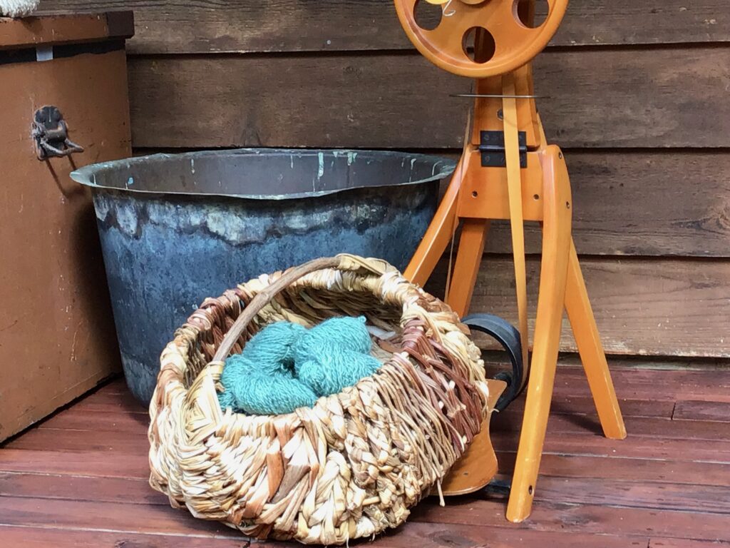 Blue handspun yarn in a brown wicker basket